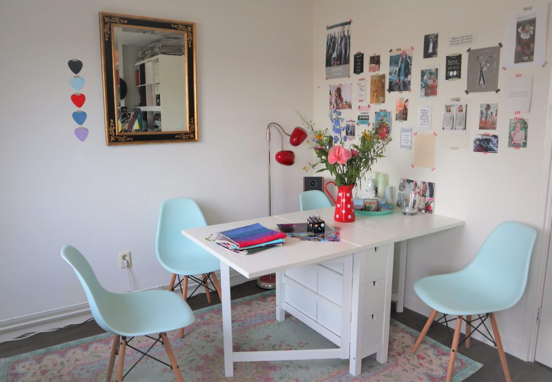Ebrina's studio in Zwolle met een witte tafel en lichtblauwe stoelen