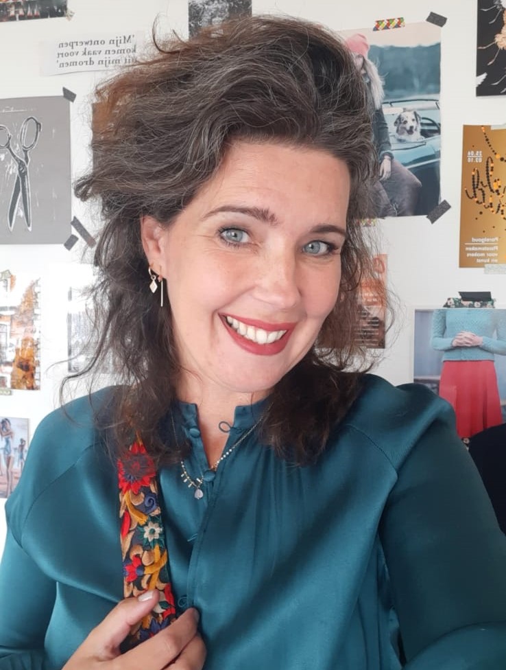 Ebrina in een petrolblauwe blouse voor de inspiratiewand