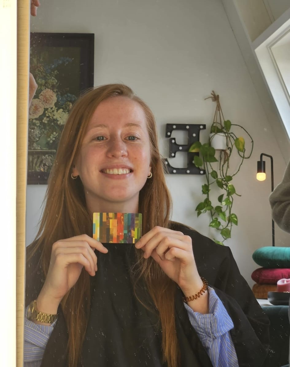Vrouw houdt haar kleurenkaart vast tegen een donkere trui